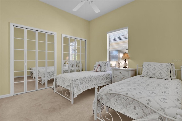 carpeted bedroom with multiple closets and ceiling fan