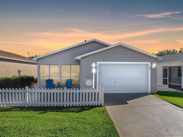 view of front of property with a garage and a yard