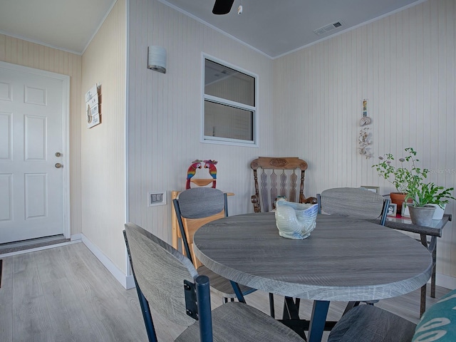 dining space with light hardwood / wood-style flooring, ceiling fan, and ornamental molding