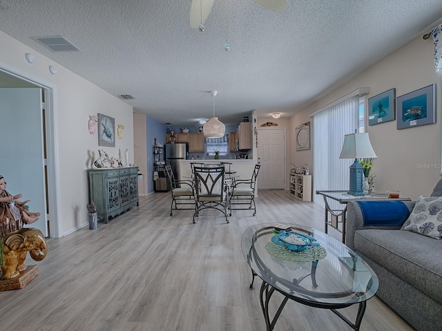 living room featuring a textured ceiling and light hardwood / wood-style flooring