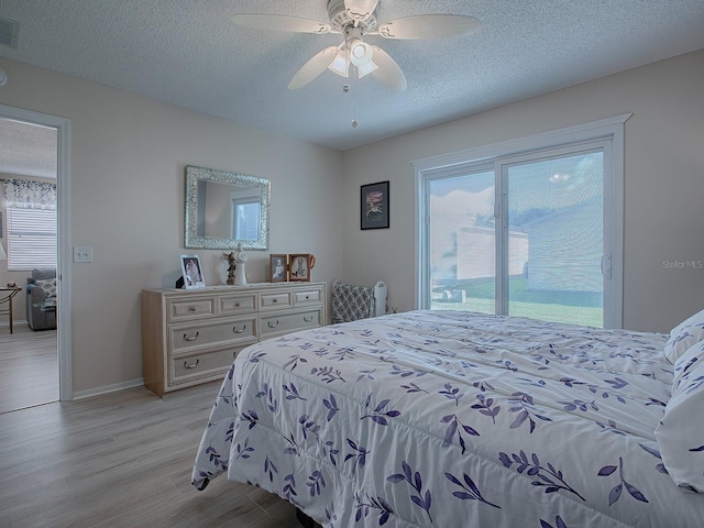 bedroom featuring access to exterior, ceiling fan, a textured ceiling, and light wood-type flooring