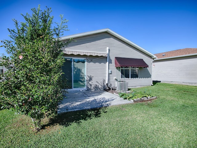 back of property featuring central air condition unit and a lawn