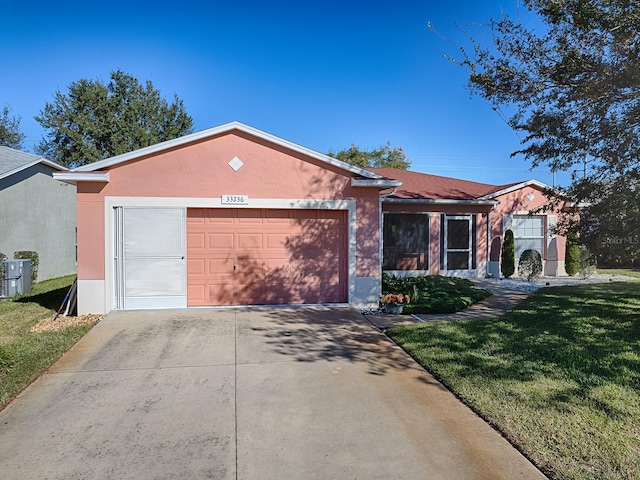 single story home with a garage and a front lawn