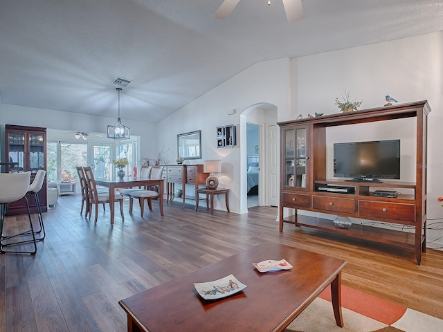 33236 Grand Cypress Way, Leesburg, FL 34748 - living room with arched walkways, lofted ceiling, a ceiling fan, and wood finished floors