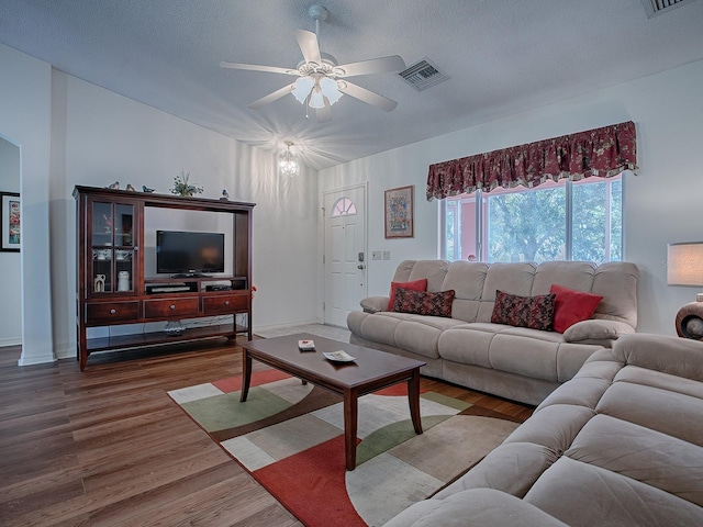 33236 Grand Cypress Way, Leesburg, FL 34748 - living area with a ceiling fan, wood finished floors, a textured ceiling, vaulted ceiling, and baseboards