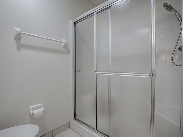 33236 Grand Cypress Way, Leesburg, FL 34748 - bathroom with a shower with shower door, toilet, and tile patterned floors