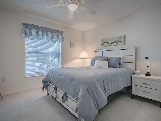 carpeted bedroom with a textured ceiling and ceiling fan