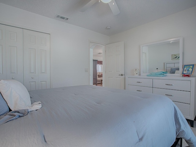 bedroom with a textured ceiling, a closet, and ceiling fan