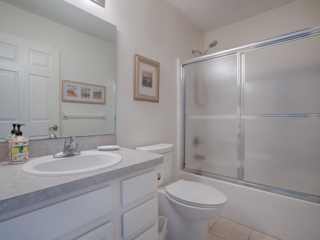 full bathroom with vanity, tile patterned floors, toilet, enclosed tub / shower combo, and a textured ceiling