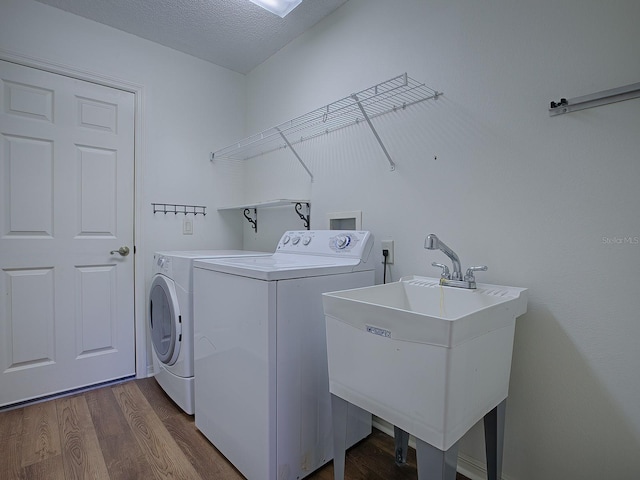 laundry room with dark hardwood / wood-style flooring, washer and clothes dryer, a textured ceiling, and sink