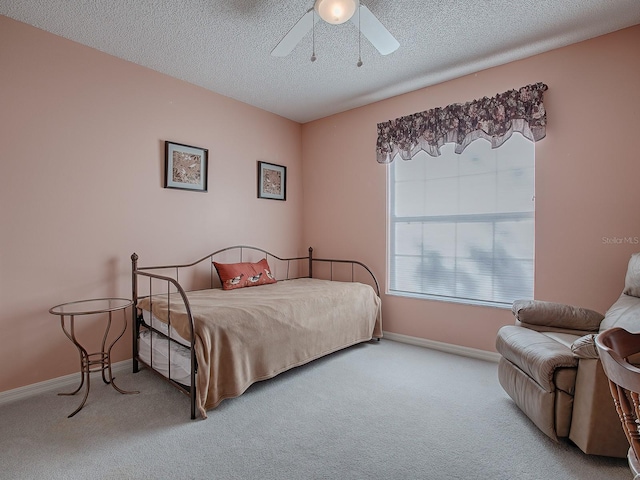 bedroom featuring carpet, a textured ceiling, and ceiling fan