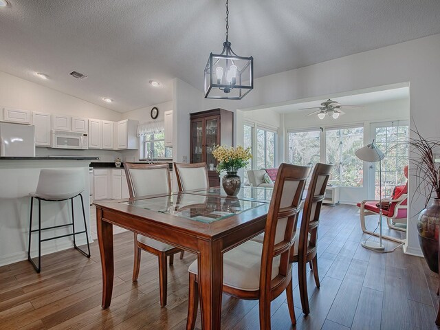 33236 Grand Cypress Way, Leesburg, FL 34748 - dining room with dark wood-type flooring, lofted ceiling, a ceiling fan, a textured ceiling, and recessed lighting
