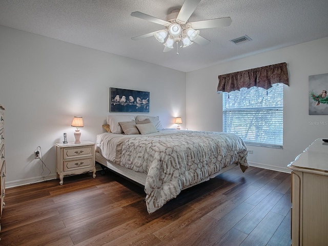 33236 Grand Cypress Way, Leesburg, FL 34748 - bedroom with dark wood-style flooring, a textured ceiling, and a ceiling fan
