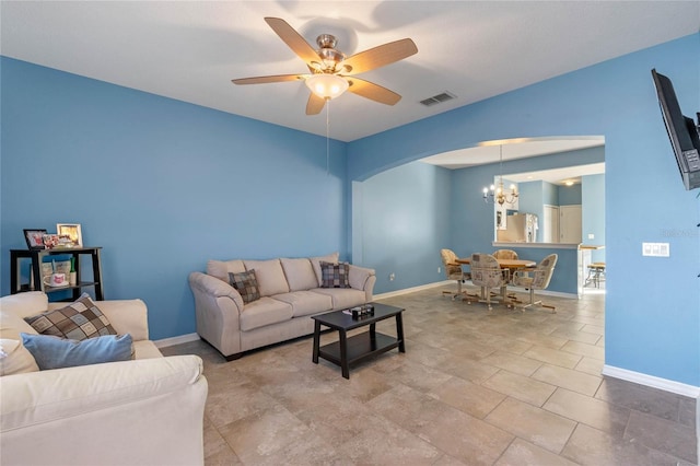 living area with baseboards, visible vents, arched walkways, and ceiling fan with notable chandelier