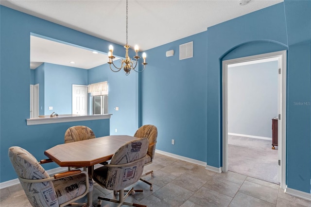 dining area featuring visible vents, a notable chandelier, and baseboards