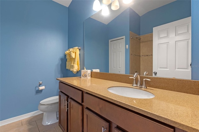 bathroom with tile patterned flooring, toilet, vanity, baseboards, and walk in shower