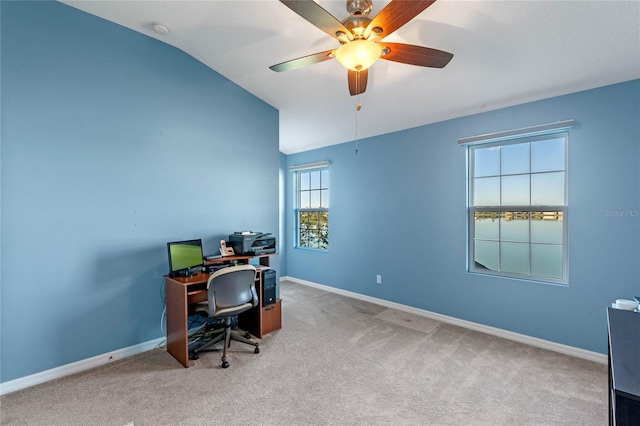 carpeted home office with vaulted ceiling, a ceiling fan, and baseboards