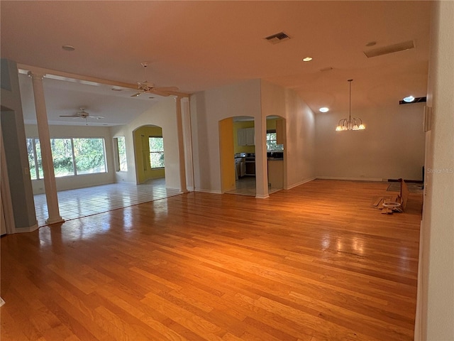 spare room featuring light hardwood / wood-style flooring and ceiling fan with notable chandelier