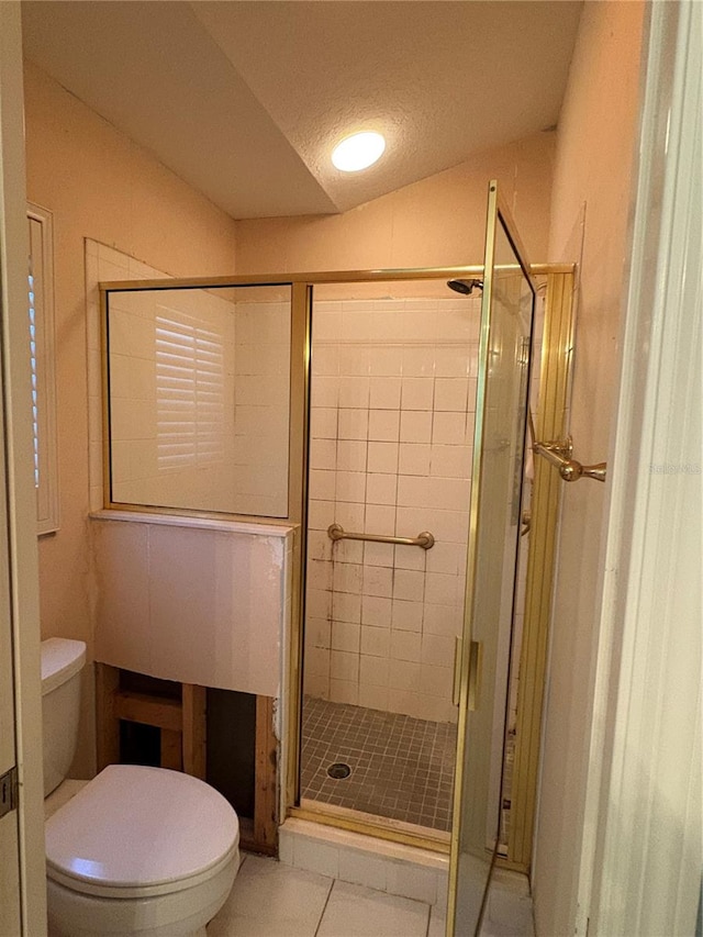 bathroom featuring tile patterned floors, an enclosed shower, a textured ceiling, toilet, and lofted ceiling