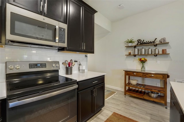 kitchen with decorative backsplash, stainless steel appliances, and light hardwood / wood-style floors