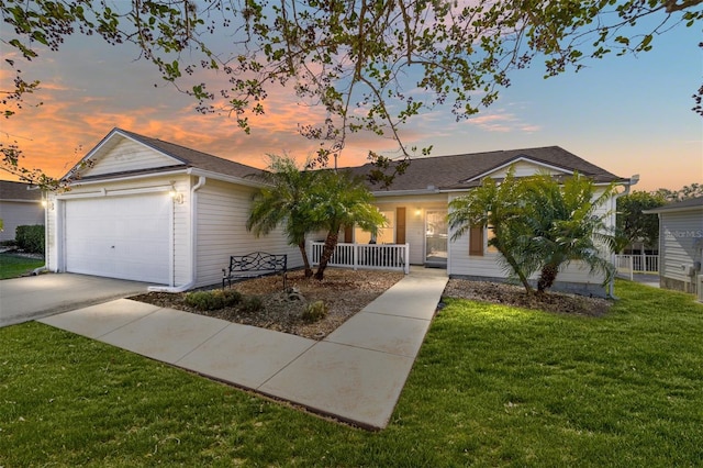 ranch-style house with a lawn, a porch, and a garage