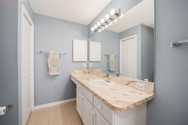 bathroom with tile patterned floors, vanity, and a textured ceiling