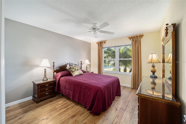 bedroom featuring ceiling fan, a textured ceiling, and light hardwood / wood-style flooring