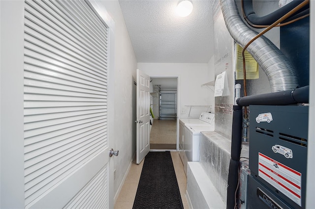 washroom with independent washer and dryer, a textured ceiling, heating unit, and light tile patterned flooring