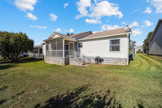 back of property featuring a lawn and a sunroom