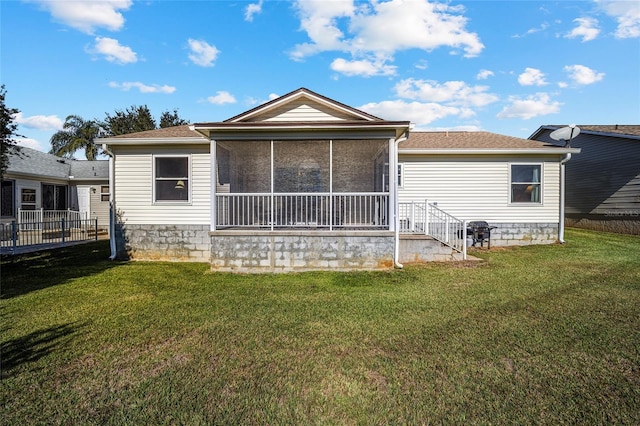 back of house featuring a lawn and a sunroom