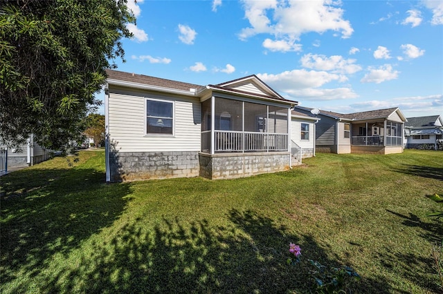 back of house featuring a lawn and a sunroom