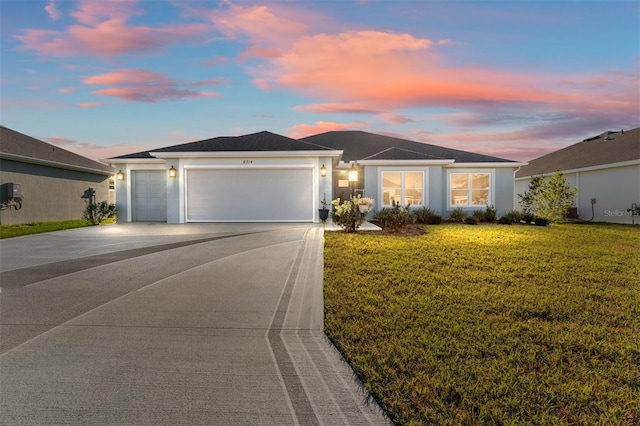 single story home featuring a lawn and a garage