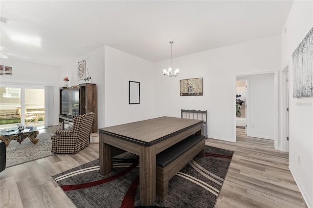 dining space featuring an inviting chandelier and light wood-type flooring