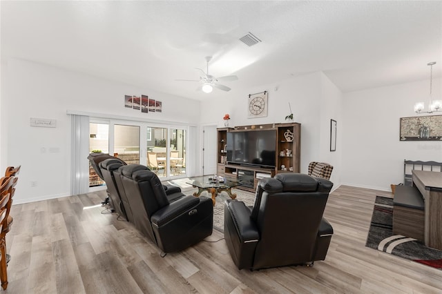 living room featuring light hardwood / wood-style flooring and ceiling fan with notable chandelier