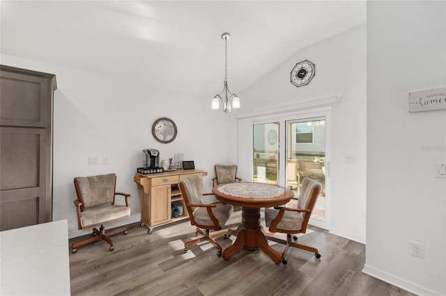 dining area featuring dark hardwood / wood-style floors, a chandelier, and vaulted ceiling