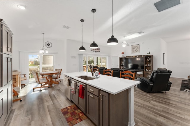 kitchen featuring pendant lighting, light hardwood / wood-style flooring, a kitchen island with sink, and sink