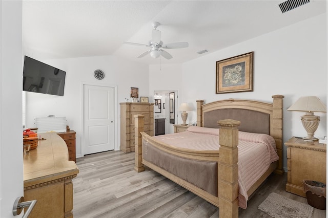 bedroom featuring light hardwood / wood-style flooring, vaulted ceiling, ceiling fan, and ensuite bathroom