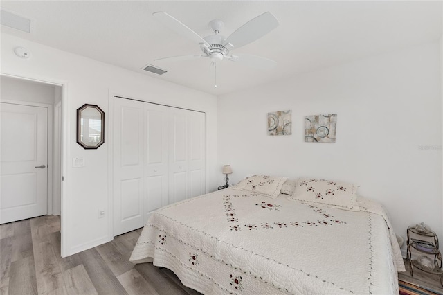 bedroom featuring ceiling fan, a closet, and light wood-type flooring