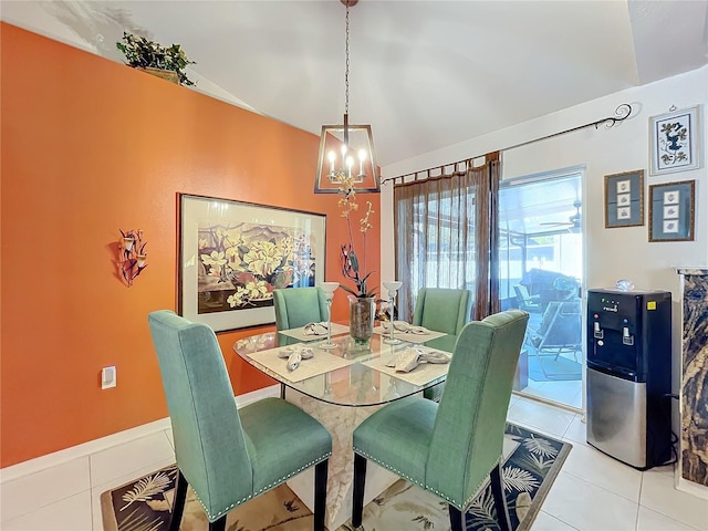 dining area featuring a notable chandelier, light tile patterned flooring, and lofted ceiling