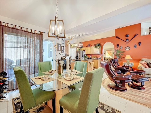 tiled dining room with an inviting chandelier