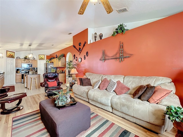 living room featuring ceiling fan and light hardwood / wood-style floors