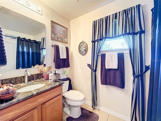 bathroom with tile patterned flooring, vanity, toilet, and a textured ceiling