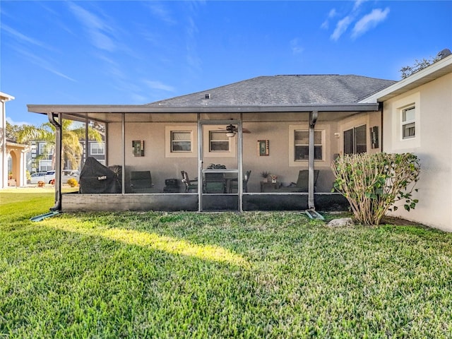 rear view of property with a lawn, a sunroom, and ceiling fan