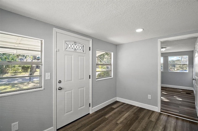 foyer with a textured ceiling and dark wood-type flooring