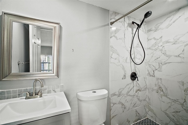 bathroom featuring tiled shower, vanity, and toilet