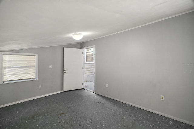 unfurnished room featuring crown molding and lofted ceiling