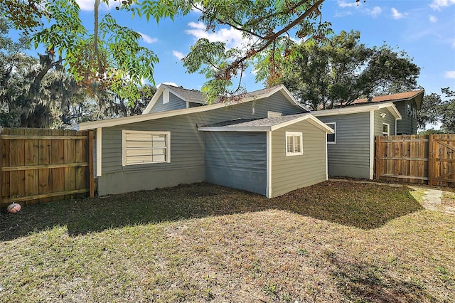 rear view of property featuring a lawn