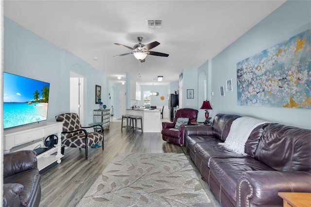 living room featuring hardwood / wood-style floors and ceiling fan