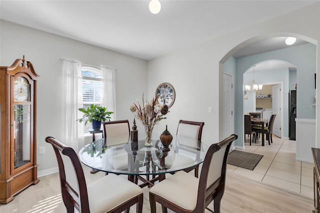 dining area with a notable chandelier and light tile patterned flooring