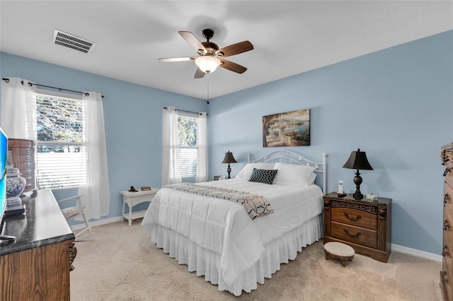 carpeted bedroom with multiple windows and ceiling fan